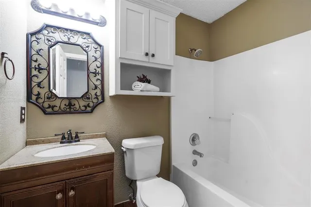 a house that is sitting in the grass with tress in the background