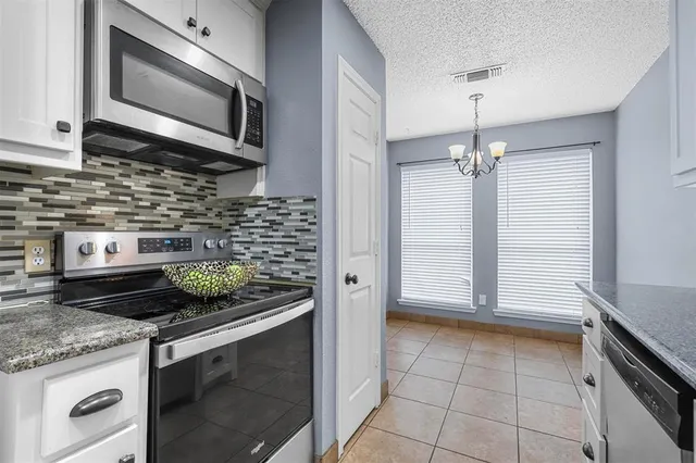 a kitchen with stainless steel appliances granite countertop a sink and a stove