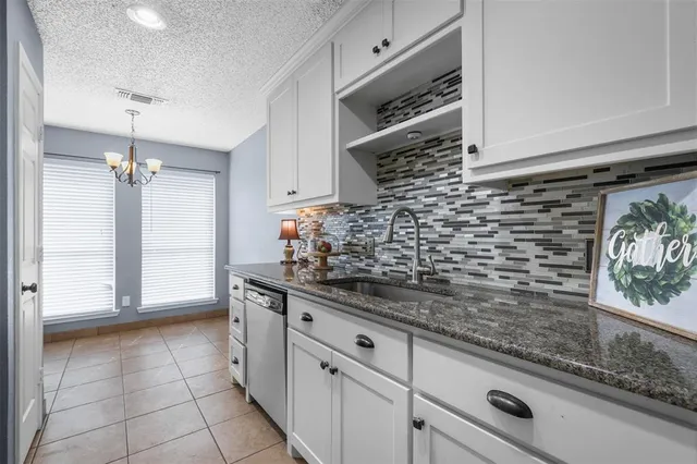 a spacious bedroom with a bed and a chandelier