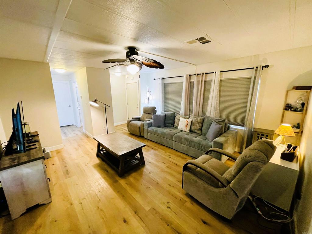 4660 North River Road, Unit 95 Oceanside, CA 92057 - Photo 6 of 37 a living room with furniture and a flat screen tv