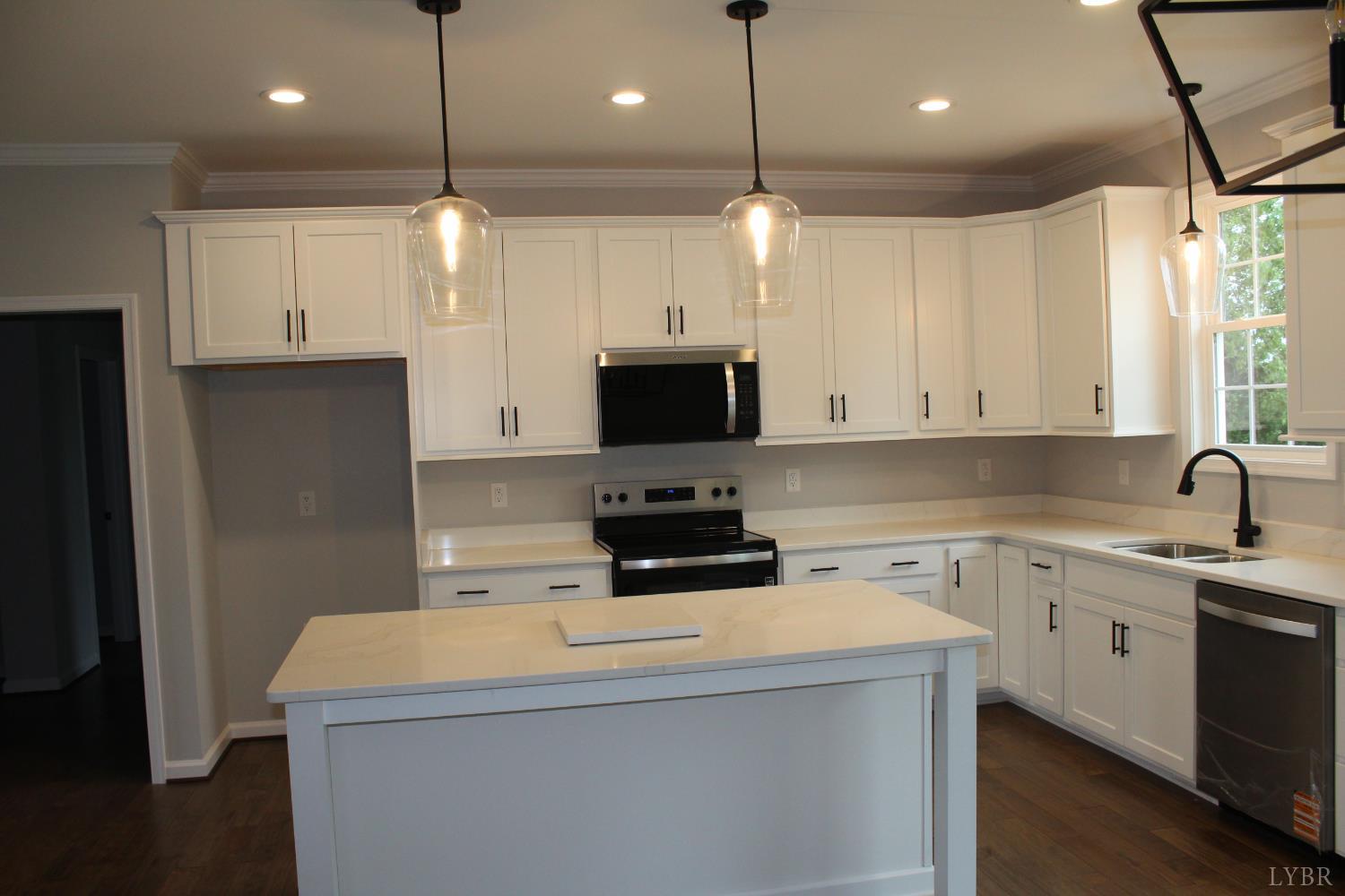 1493 Buck Crk Road Appomattox, VA 24522 - Photo 8 of 18 a kitchen with a sink a center island a stove and a refrigerator
