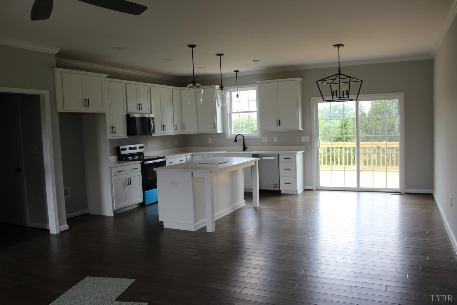 1493 Buck Crk Road Appomattox, VA 24522 - Photo 9 of 18 a kitchen with stainless steel appliances wooden floors and white cabinets