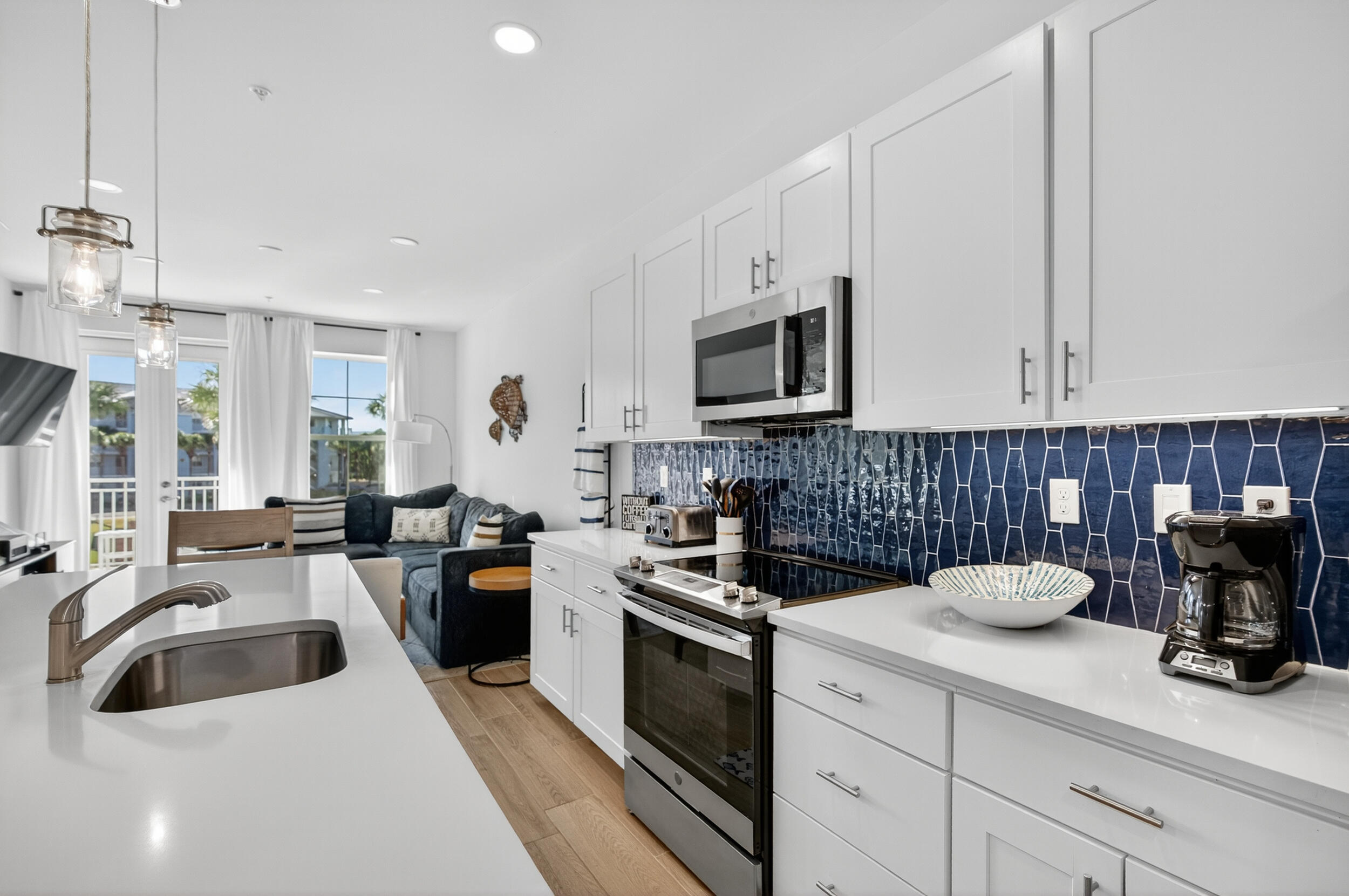 1740 South Co Highway 393, Unit 103 Santa Rosa Beach, FL 32459 - Photo 13 of 73 a kitchen with a sink white cabinets and white appliances