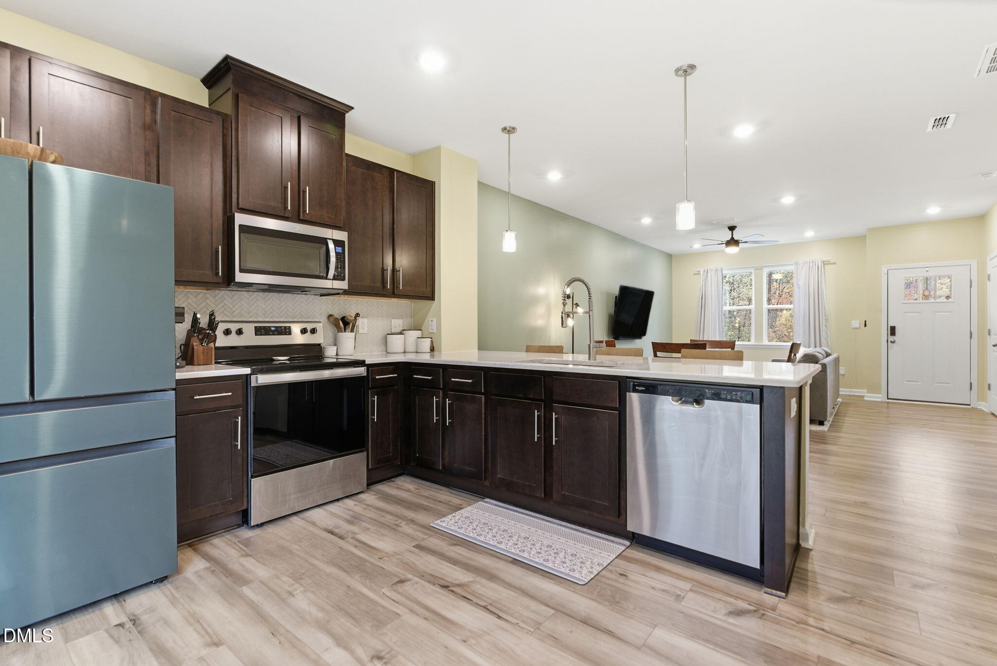 449 Hacksaw Trail Raleigh, NC 27610 - Photo 14 of 36 a kitchen with stainless steel appliances kitchen island granite countertop a refrigerator and a stove top oven