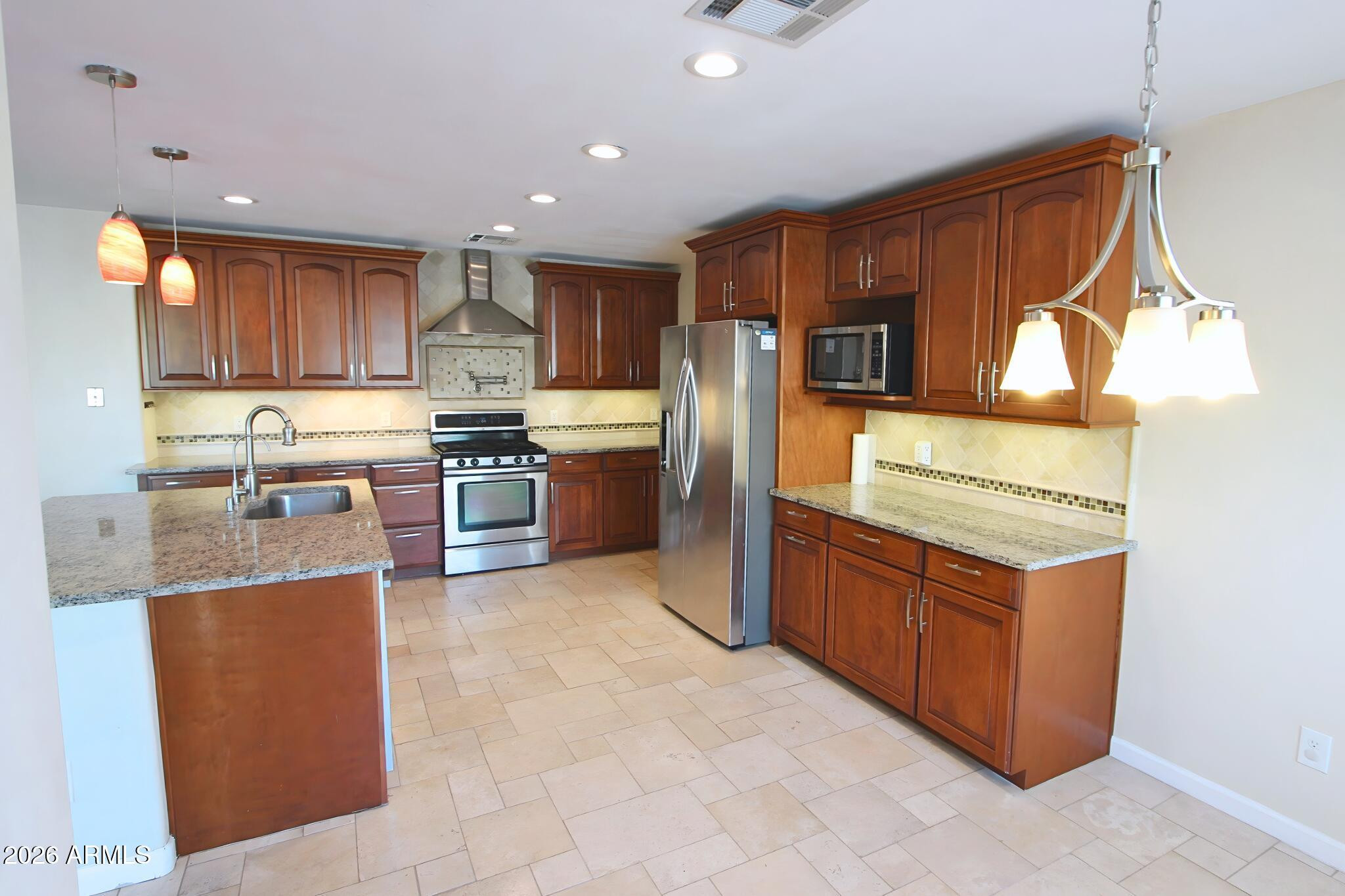 1250 South Palm Street Gilbert, AZ 85296 - Photo 9 of 33 a kitchen with stainless steel appliances granite countertop a stove a sink and a refrigerator