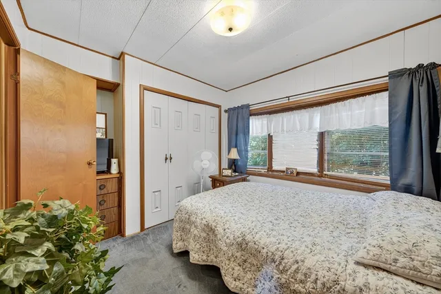 a bed sitting in a spacious bedroom next to a window