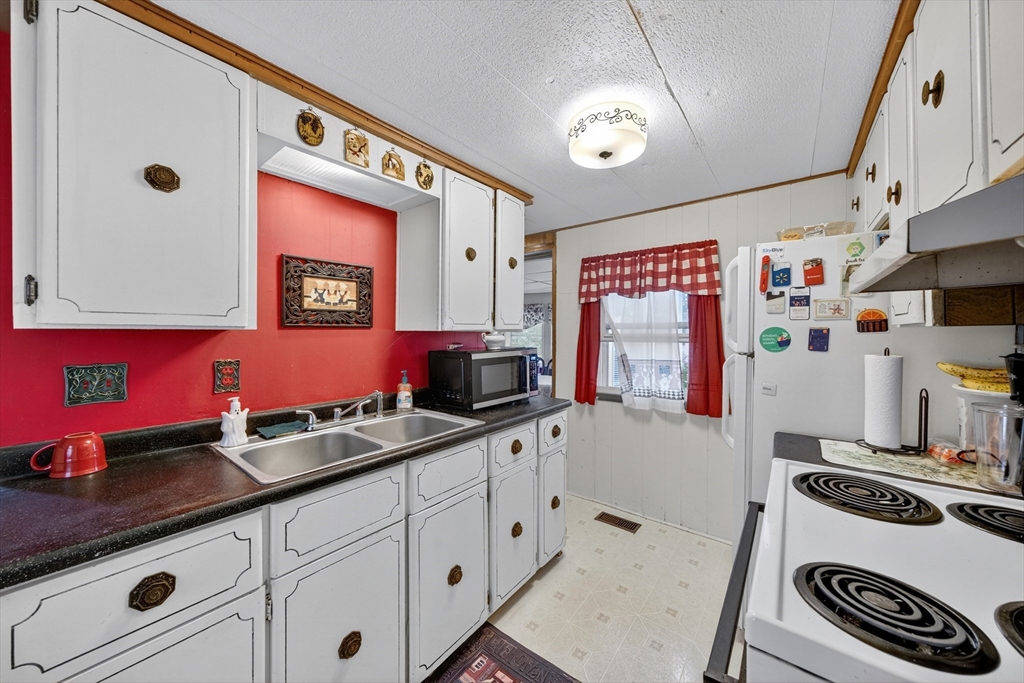 59 Timber Lane Wareham, MA 02576 - Photo 24 of 30 a kitchen with granite countertop a sink stove and cabinets