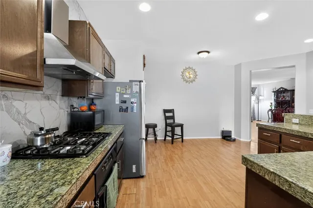 a kitchen with a stove and a wooden floor
