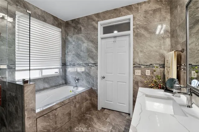 a spacious bathroom with a granite countertop tub sink and mirror