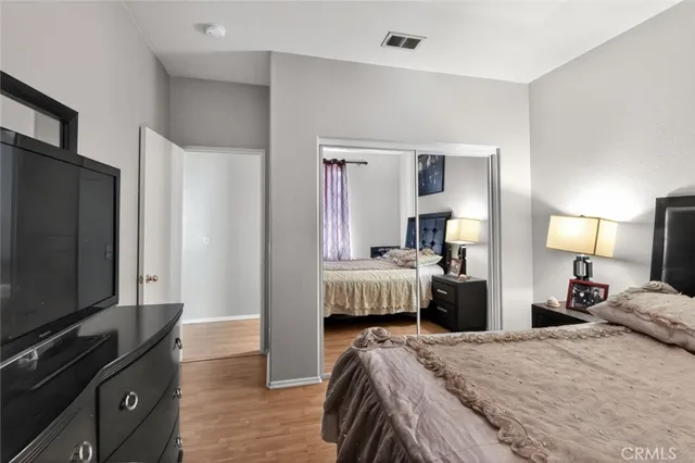 a bedroom with a bed and a flat tv screen on dresser