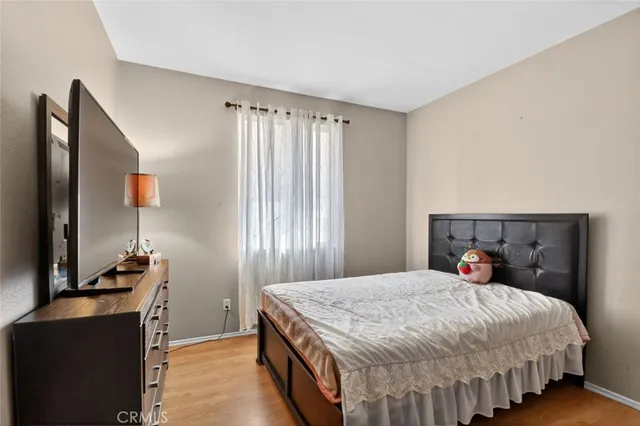 a bedroom with a bed and a flat tv screen on the dresser
