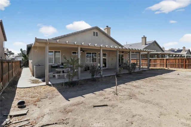 a view of a patio with a table and chairs under an umbrella