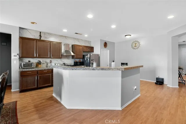 a kitchen with kitchen island granite countertop a sink a counter top space stainless steel appliances and cabinets