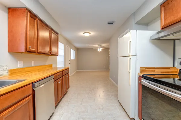 a kitchen with stainless steel appliances granite countertop a refrigerator and a stove top oven