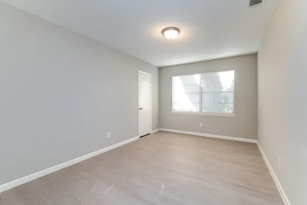 an empty room with windows and closet
