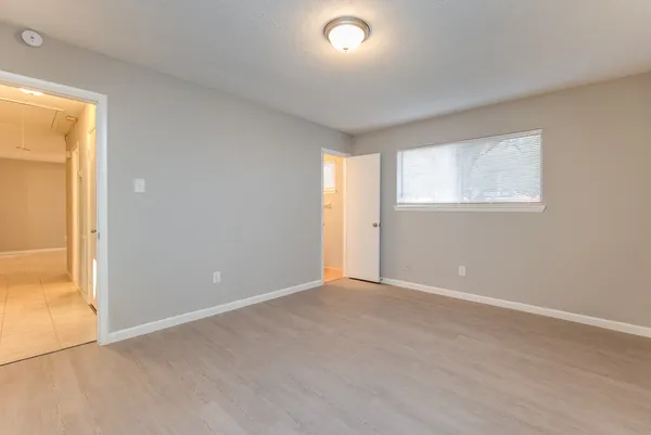 an empty room with windows and closet