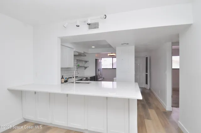a kitchen with stainless steel appliances a sink a stove a refrigerator and cabinets