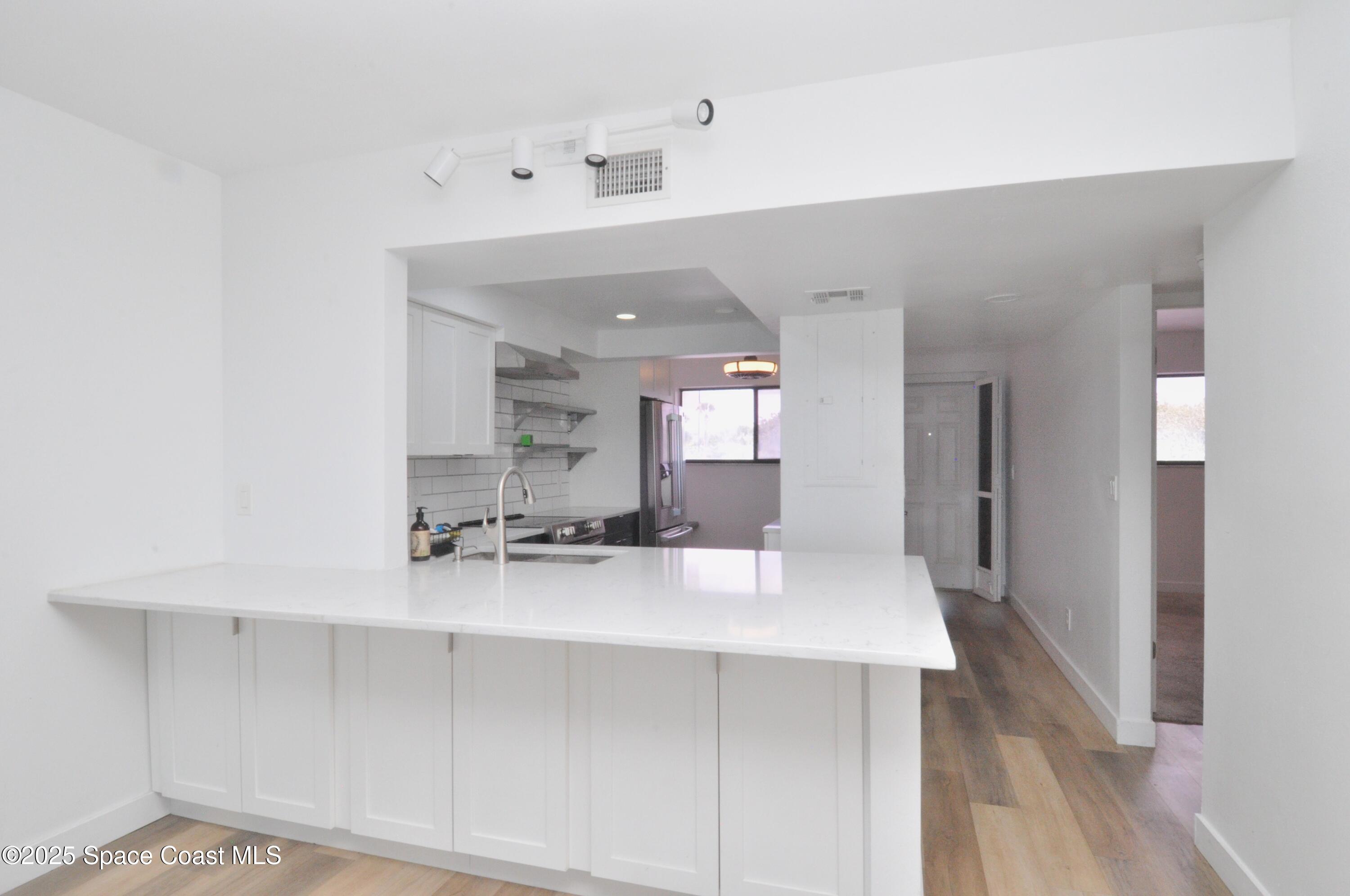 3901 Dixie Highway Northeast, Unit 402 Palm Bay, FL 32905 - Photo 18 of 33 a large white kitchen with kitchen island a sink stainless steel appliances and cabinets