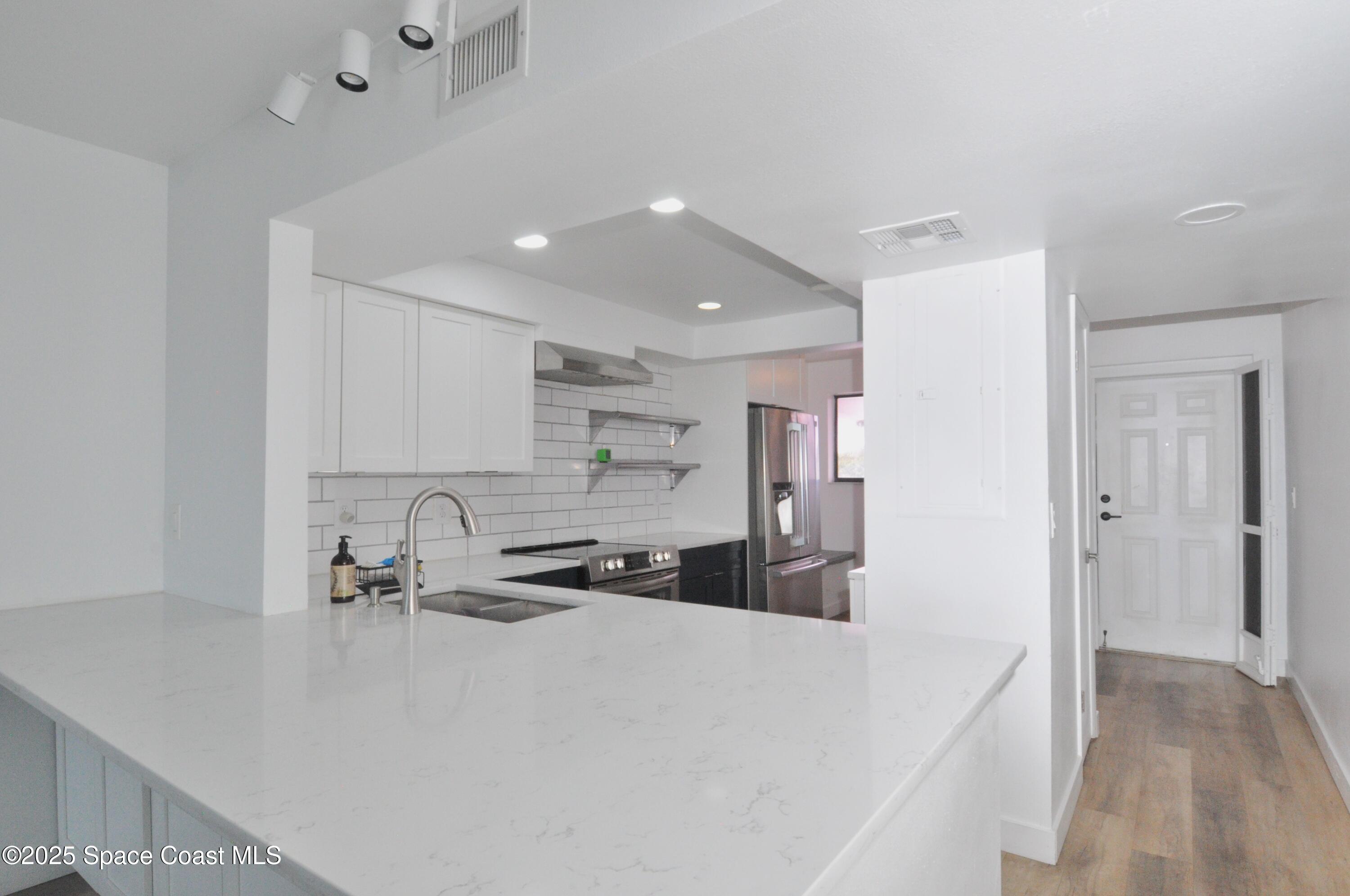 3901 Dixie Highway Northeast, Unit 402 Palm Bay, FL 32905 - Photo 19 of 33 a kitchen with stainless steel appliances a sink a stove a refrigerator and cabinets