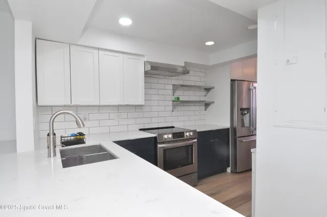 a view of a hallway with a chair and frames on the wall