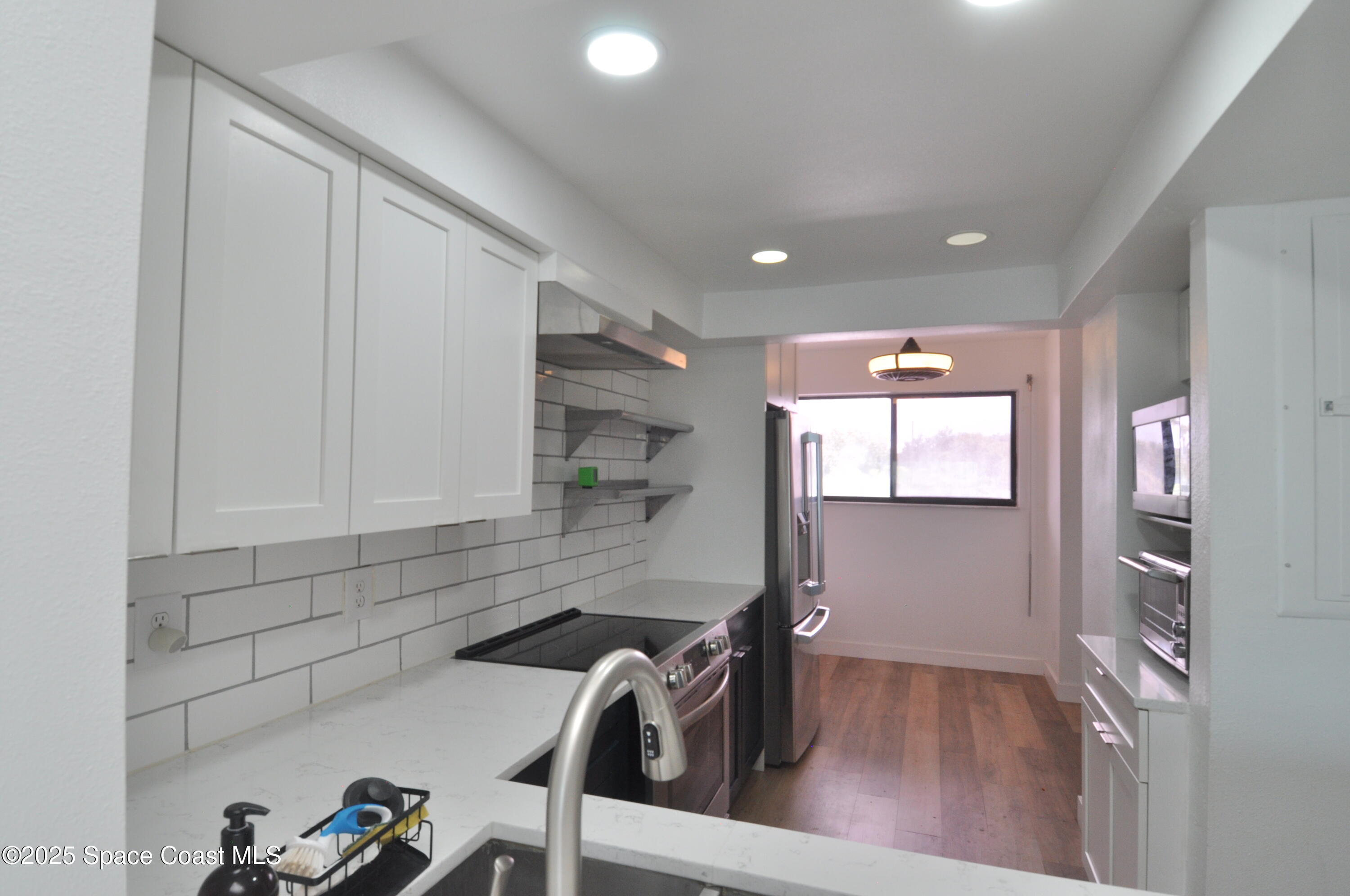 3901 Dixie Highway Northeast, Unit 402 Palm Bay, FL 32905 - Photo 21 of 33 a view of a hallway with a chair and frames on the wall