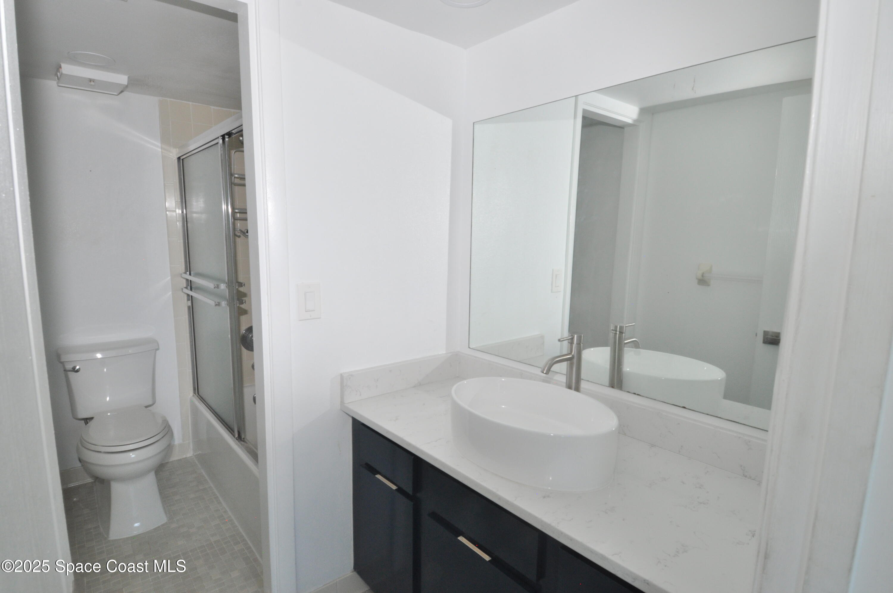 3901 Dixie Highway Northeast, Unit 402 Palm Bay, FL 32905 - Photo 24 of 33 a bathroom with a sink toilet and a mirror