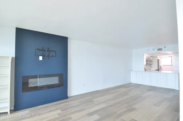 a view of an empty room and kitchen