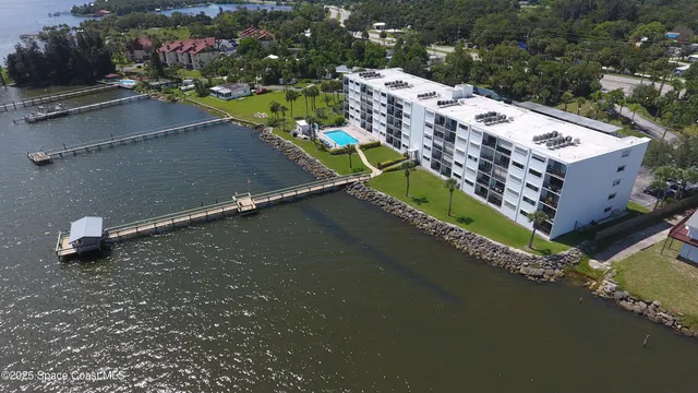 an aerial view of a house with a garden and lake view
