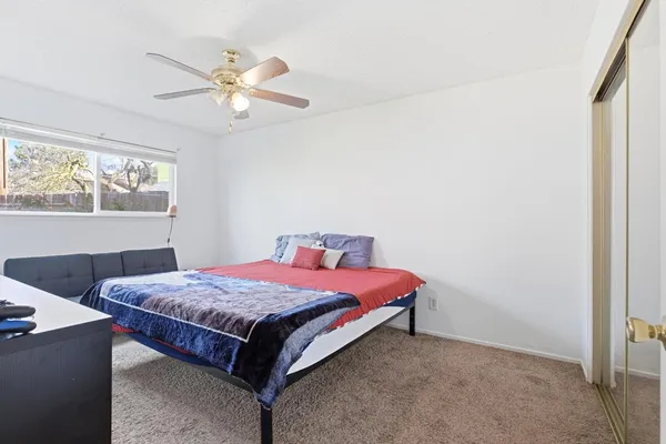 a bed sitting in a bedroom next to a window