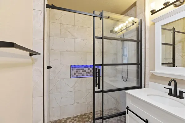 a bathroom with a shower sink and mirror