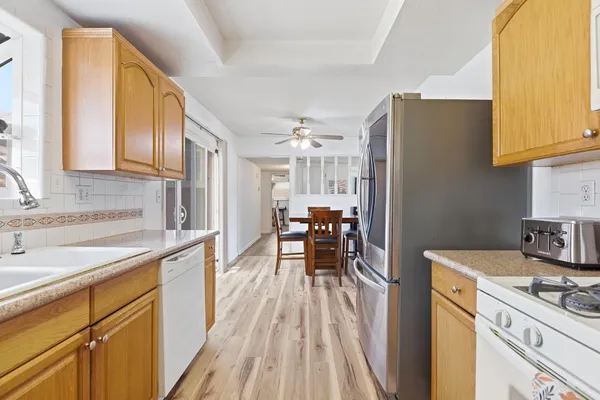 a kitchen with granite countertop a refrigerator stove top oven and sink