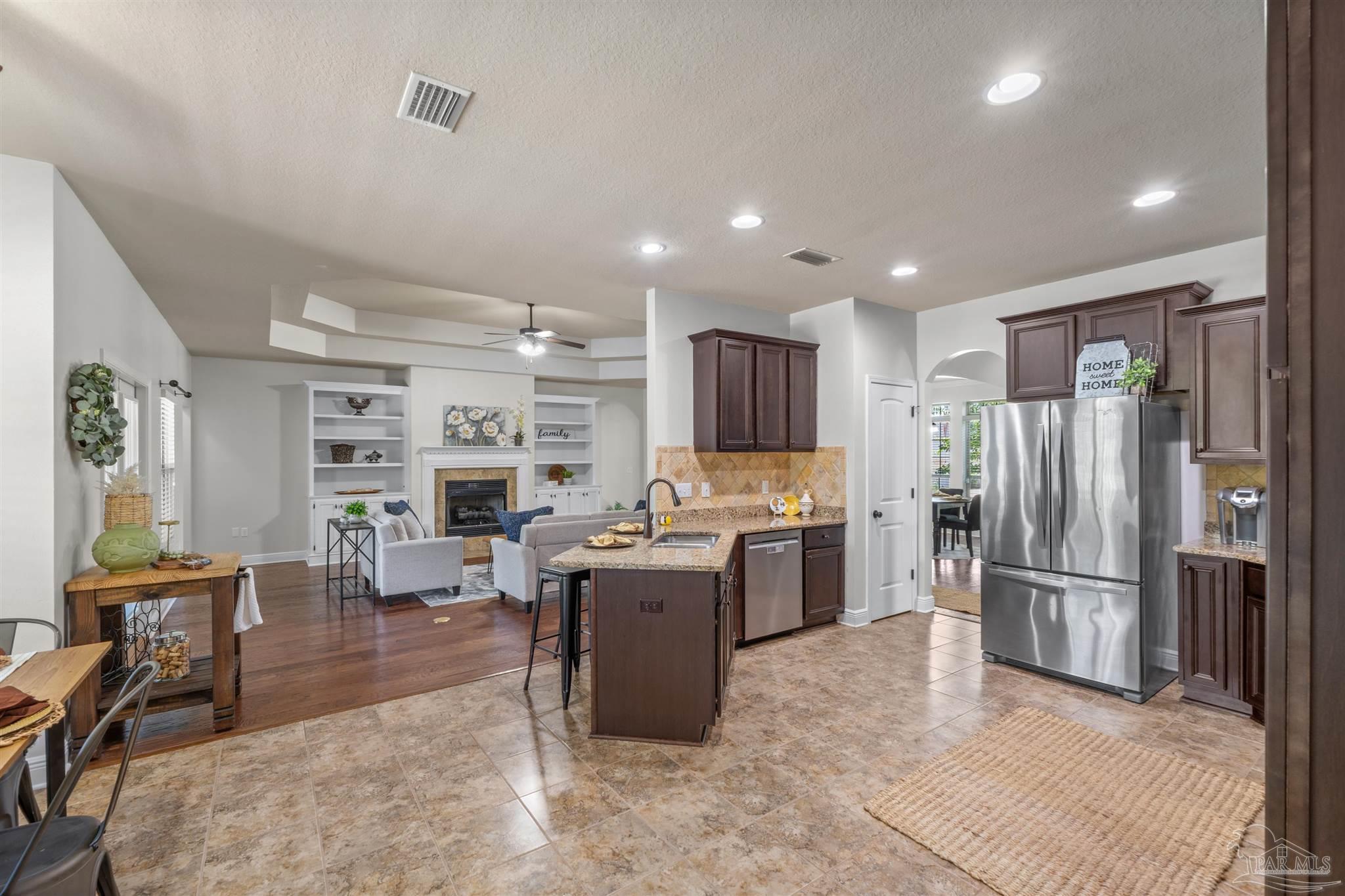 2698 Tulip Hill Road Pace, FL 32571 - Photo 22 of 65 a kitchen with a refrigerator and a stove top oven
