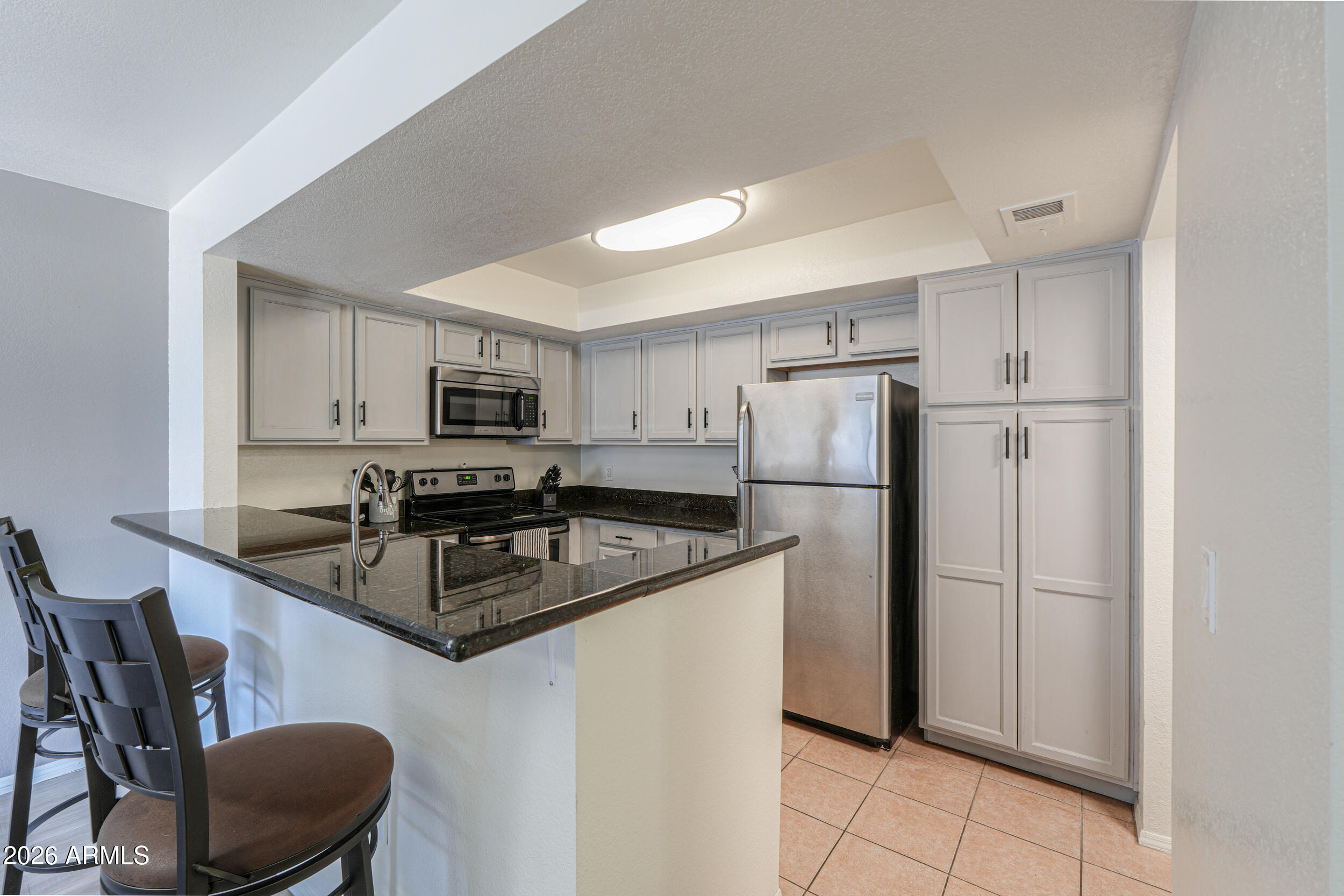 1331 West Baseline Road, Unit 225 Mesa, AZ 85202 - Photo 11 of 47 a kitchen with stainless steel appliances granite countertop a refrigerator a stove a sink a microwave and a refrigerator