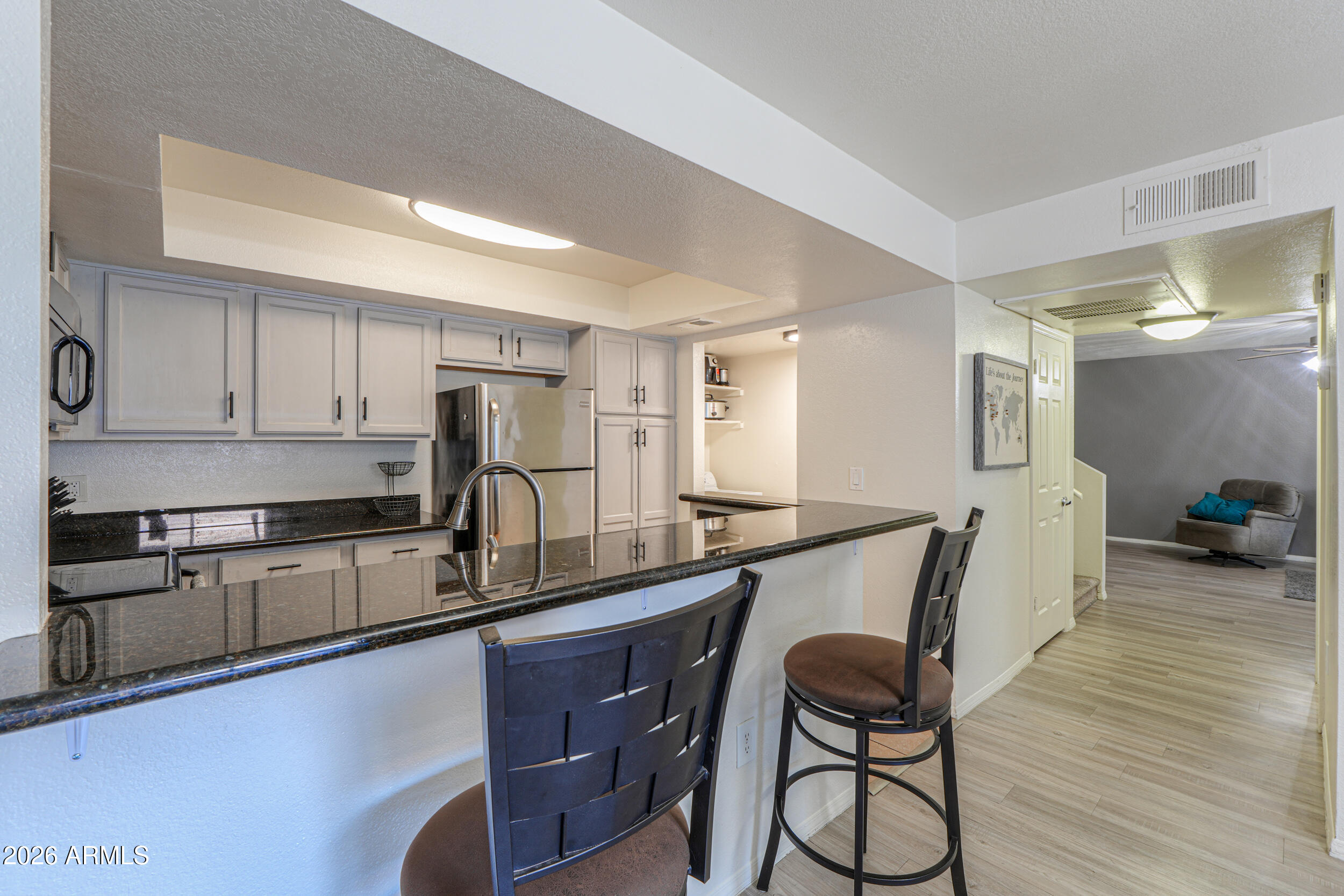 1331 West Baseline Road, Unit 225 Mesa, AZ 85202 - Photo 12 of 47 a kitchen with granite countertop a table chairs stove refrigerator and cabinets