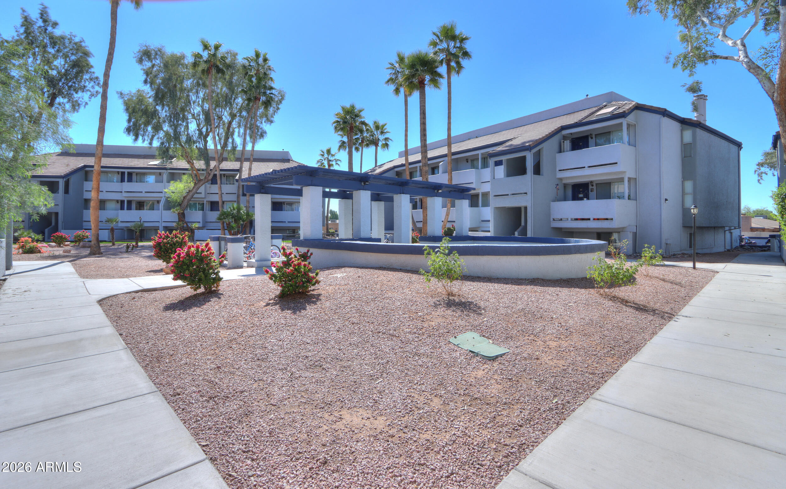 1331 West Baseline Road, Unit 225 Mesa, AZ 85202 - Photo 43 of 47 a tall building with trees in front of it