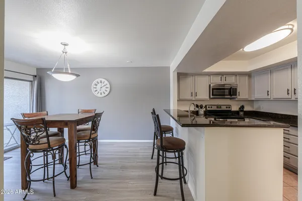 a kitchen with a table chairs refrigerator and microwave