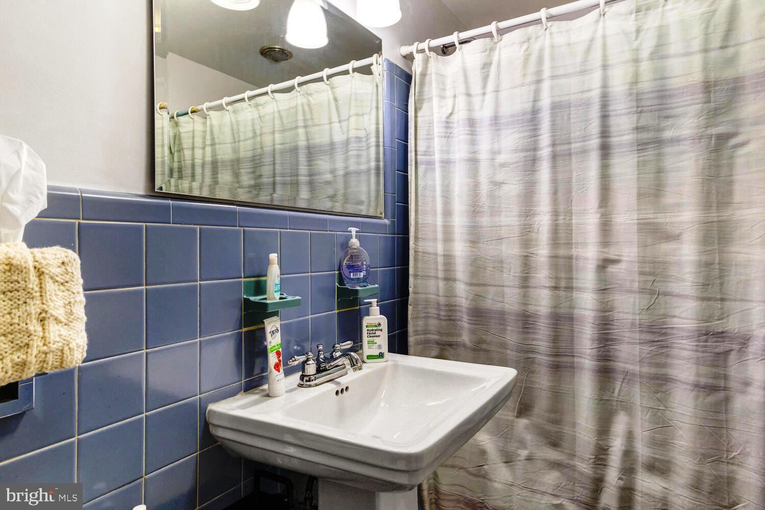 7900 Old York Road, Unit 907A Elkins Park, PA 19027 - Photo 22 of 36 a bathroom with a sink a toilet and shower curtain