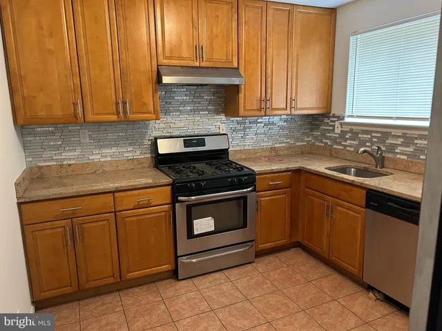 a kitchen with granite countertop cabinets stainless steel appliances and a sink