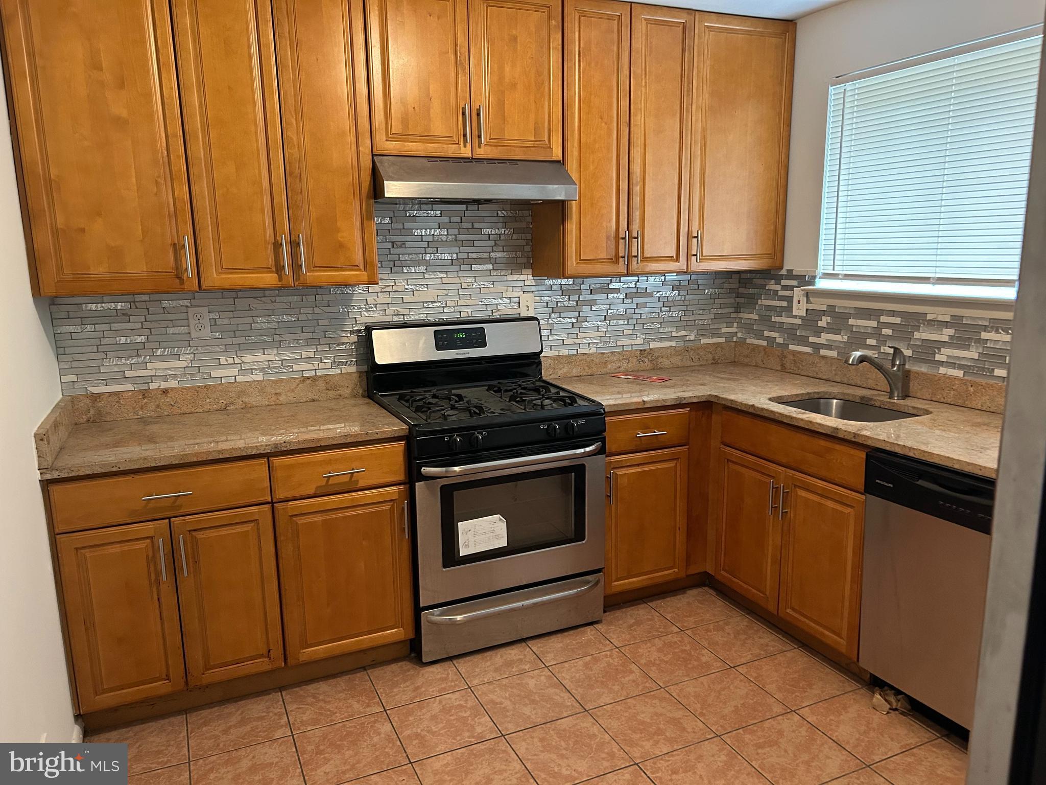 a kitchen with granite countertop cabinets stainless steel appliances and a sink