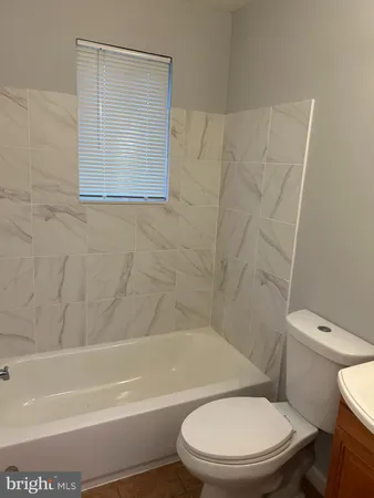 a white toilet and tub sitting next to a bathroom sink