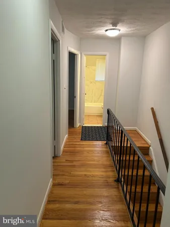 a view of a hallway with wooden floor and staircase