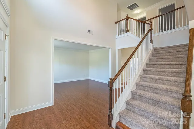 a view of staircase with wooden floor and a chandelier