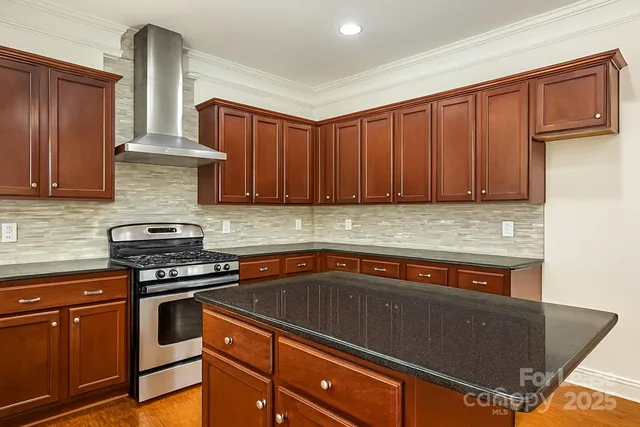 a kitchen with stainless steel appliances granite countertop a stove a sink and a microwave