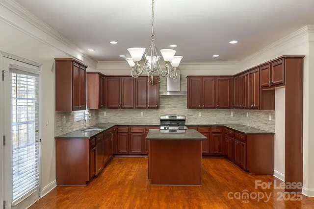 a kitchen with kitchen island granite countertop stainless steel appliances and cabinets