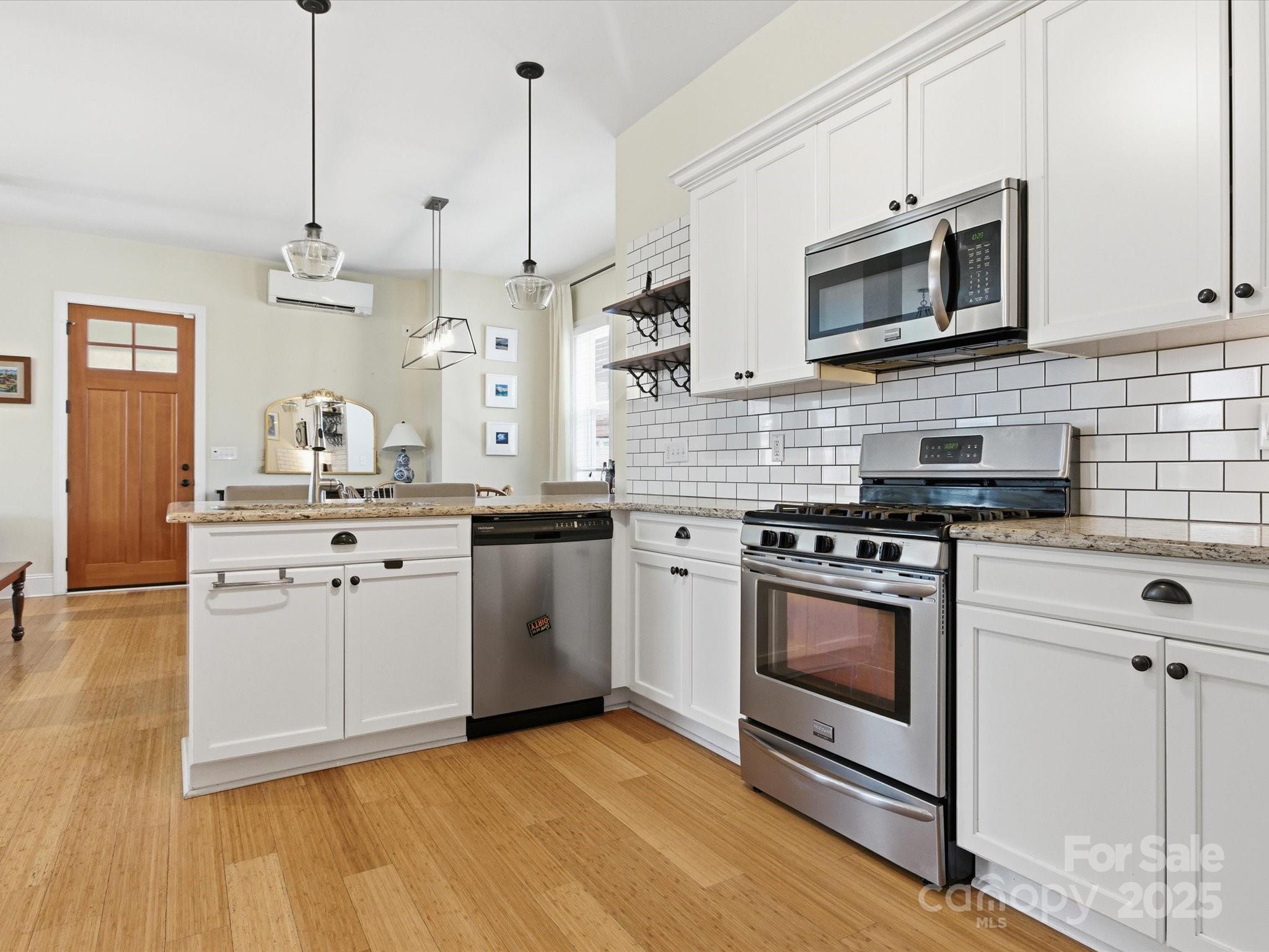 116 Meyers Ridge Road Cramerton, NC 28032 - Photo 6 of 33 a kitchen with stainless steel appliances granite countertop a sink a stove a microwave and wooden floors