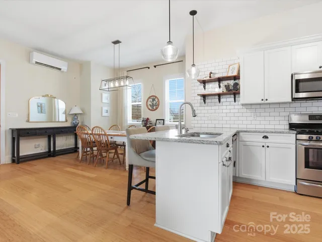 a kitchen with kitchen island granite countertop a sink cabinets and stainless steel appliances