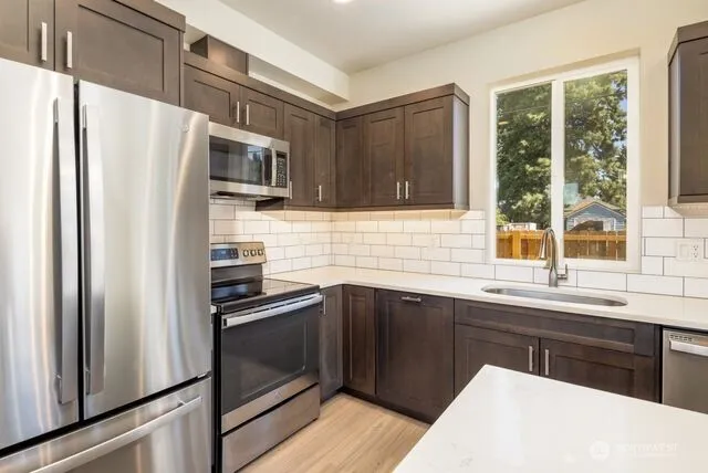 a kitchen with stainless steel appliances a refrigerator sink and microwave