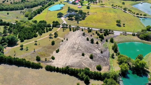 an aerial view of a house with a yard and greenery
