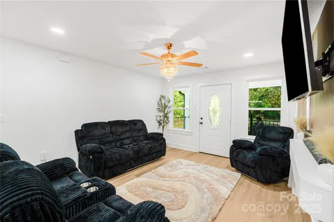 a kitchen with stainless steel appliances a dining table chairs refrigerator and sink