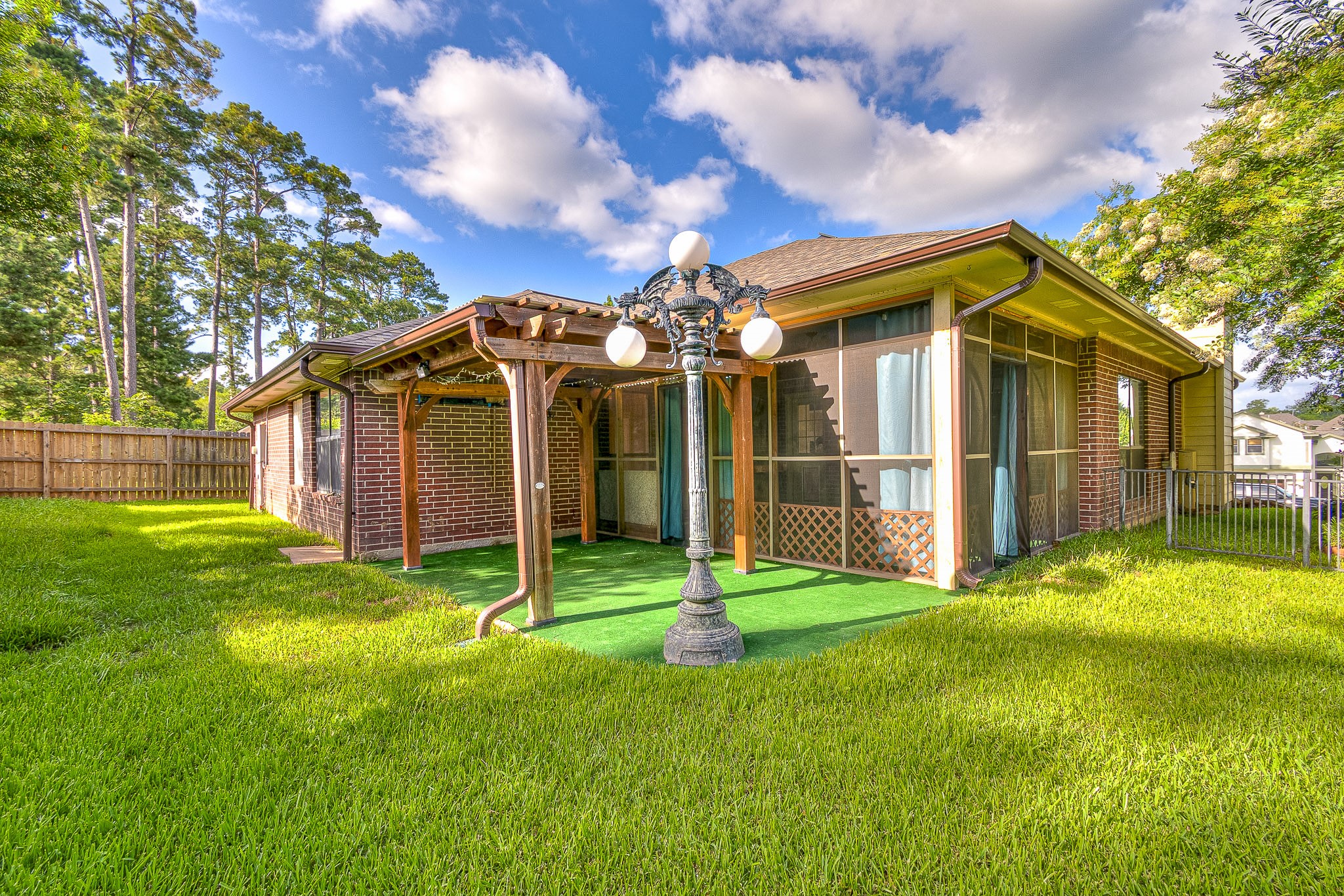 12557 Marina Loop Willis, TX 77318 - Photo 23 of 36 View of fenced in backyard with pergola and screened in porch